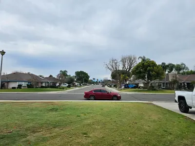 a red car driving down a street with a truck at Spacious 2 story 1 bedroom home with pool in Rio Bravo