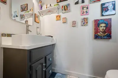 a bathroom with a sink and pictures on the wall at Middlebury Heights with Pool in Los Angeles