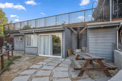 a patio with a picnic table and a balcony at Middlebury Heights with Pool in Los Angeles