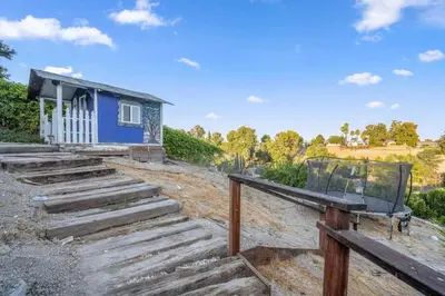 a blue house with a bench on the stairs at Middlebury Heights with Pool in Los Angeles
