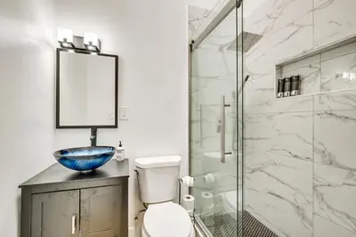 a bathroom with a toilet and a glass shower at Lake Arrowhead Hideaway with Deck and Hot Tub in Lake Arrowhead