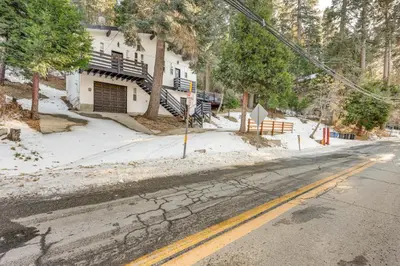 an empty street in front of a house in the snow at Lake Arrowhead Hideaway with Deck and Hot Tub in Lake Arrowhead