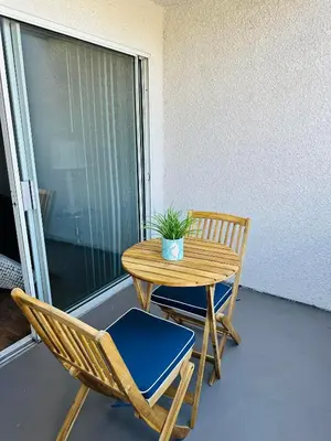 a table and chairs on a balcony with a potted plant at Hollywood Luxury Retreat I Pool Views I Jacuzzi I Fitness Center I Free Parking! in Los Angeles