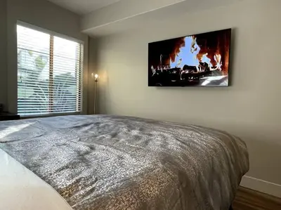 a bedroom with a large bed and a tv on the wall at Cozy 2 Bedroom 2 Bathroom Condo with Pool, Gym, Spa in Los Angeles