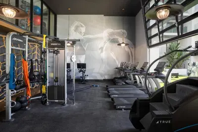 a gym with rows of exercise equipment and a wall with a mural at Blueground Long Beach pool gym nr groceries LAX-1256 in Los Angeles