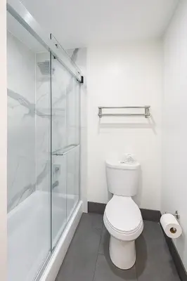 a bathroom with a toilet and a glass shower at Casa Blanca Hotel - Azusa, Los Angeles in Azusa