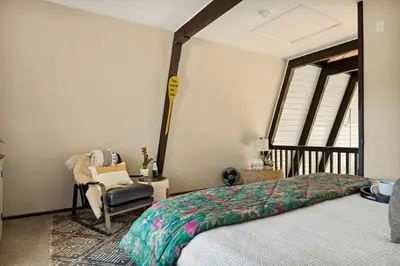 a bedroom with a bed and a chair and a window at Larks Nest in Big Bear Lake in Big Bear Lake
