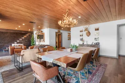 a dining room with a large wooden table and chairs at The Lazy Bear - Indulge in breathtaking views of the expansive lake from this charming cabin. in Fawnskin