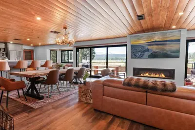 a living room with a couch and a fireplace at The Lazy Bear - Indulge in breathtaking views of the expansive lake from this charming cabin. in Fawnskin
