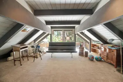 a attic room with a bed and a desk at Sunset Spectacular - Multi-level haven with water views! Incredible for 4th of July! in Big Bear Lake