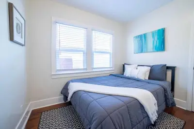 a bedroom with a blue bed and two windows at Sea View, Flower Garden, AC, WD, Renovated in Hermosa Beach