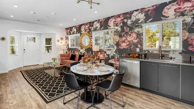 a kitchen and living room with a table and chairs at 5 Units in Heart of Hollywood Remodeled Art Deco Pink Revival by AvantStay in Los Angeles