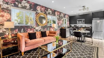 a living room with a couch and a kitchen at 5 Units in Heart of Hollywood Remodeled Art Deco Pink Revival by AvantStay in Los Angeles