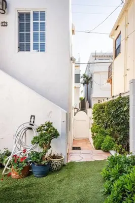 a white house with potted plants in a yard at 2min2Beach, Netflix, AC, WD,15min2LAX, Fast Wifi in Hermosa Beach