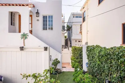 a white house with a gate and a yard at 2min2Beach, Netflix, AC, WD,15min2LAX, Fast Wifi in Hermosa Beach