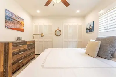 a bedroom with a white bed and a ceiling fan at Walk 2 Beach, Parking, AC, WD,15min2LAX,Remodel in Manhattan Beach