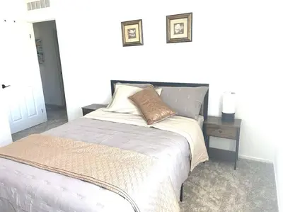 a bedroom with a bed and a side table at Modern Desert Gem, Boho Retreat 2 Living Rooms in Hesperia