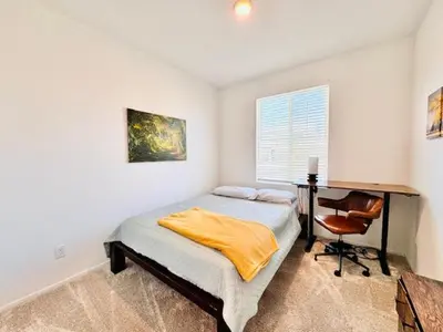 a bedroom with a bed and a desk and a chair at Modern Desert Gem, Boho Retreat 2 Living Rooms in Hesperia