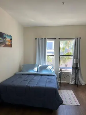 a bedroom with a blue bed and a window at SoCal Lux on Miramar in Los Angeles