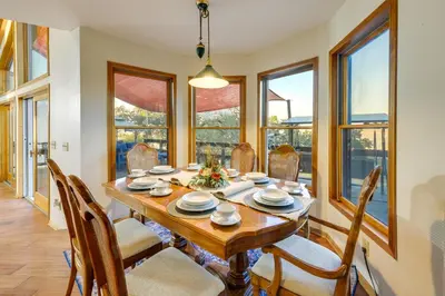 a dining room with a table and chairs and windows at Simple Life Ranch with Hot Tub and Sauna in Keene! in Keene