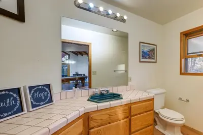 a bathroom with a sink and a toilet and a mirror at Simple Life Ranch with Hot Tub and Sauna in Keene! in Keene
