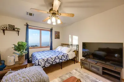 a bedroom with a bed and a flat screen tv at Simple Life Ranch with Hot Tub and Sauna in Keene! in Keene