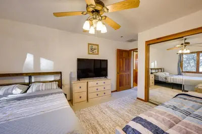 a bedroom with two beds and a flat screen tv at Simple Life Ranch with Hot Tub and Sauna in Keene! in Keene