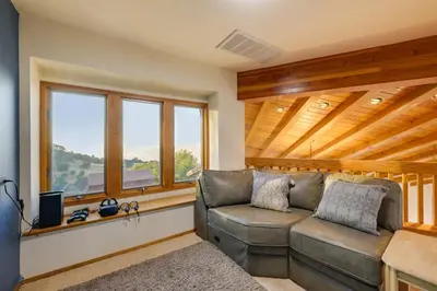 a living room with a couch and windows at Simple Life Ranch with Hot Tub and Sauna in Keene! in Keene