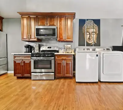 a kitchen with wooden cabinets and white appliances at Retreat with Pool in Los Angeles