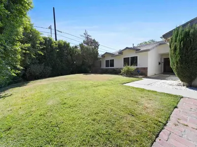 a backyard of a house with a grass yard at Retreat with Pool in Los Angeles