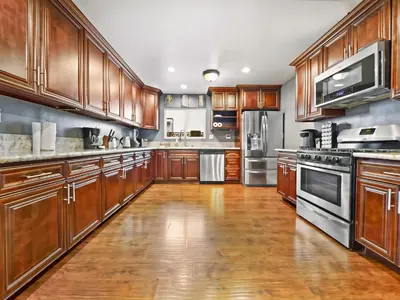 a large kitchen with wooden cabinets and stainless steel appliances at Retreat with Pool in Los Angeles