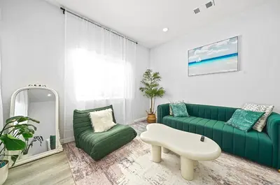 a living room with a green couch and a chair at Great Location Oasis w Huge Backyard Near DTLA ,USC ,Ktown in Los Angeles