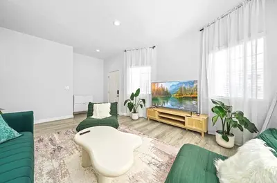 a living room with a couch and a tv at Great Location Oasis w Huge Backyard Near DTLA ,USC ,Ktown in Los Angeles