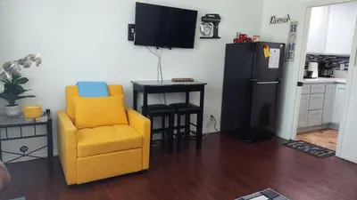 a kitchen with a yellow chair and a black refrigerator at Guestsuite in wittier in Whittier