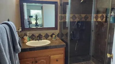 a bathroom with a sink and a shower with a mirror at Guestsuite in wittier in Whittier
