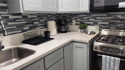 a kitchen with white cabinets and a sink and a stove at Guestsuite in wittier in Whittier