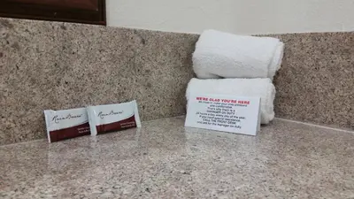two towels are sitting on a counter in a bathroom at Kona Inn Motel Anaheim in Anaheim