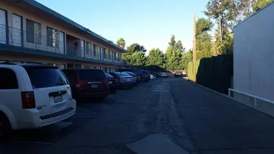 a row of cars parked in a parking lot at Kona Inn Motel Anaheim in Anaheim