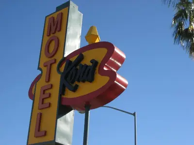 a sign for a fast food restaurant with a palm tree at Kona Inn Motel Anaheim in Anaheim