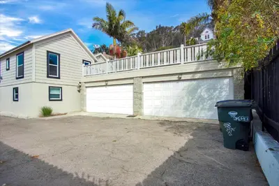 a house with a white garage with a fence at Ventura Downtown Minutes to Beaches in Ventura