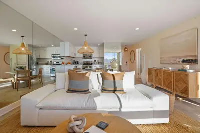 a living room with a white couch and a kitchen at Aquamarine Best View in Malibu by Stay Awhile Villas in Malibu Beach