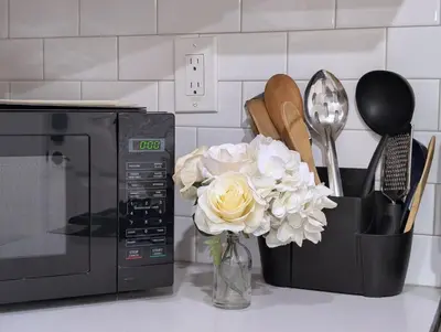 a vase of flowers sitting next to a microwave at Cozy 2B1B Guest House with Private Entrance and Parking in El Monte