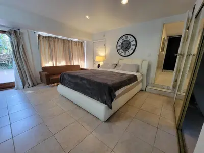 a bedroom with a bed and a clock on the wall at Private guest studio 5 minutes to Rodeo Drive and in great area in Los Angeles