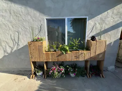 a window with potted plants on the side of a building at Vacation House in Ontario - Two Bedroom Brand New and Hand Made Furniture in Ontario