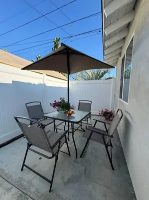 a table and chairs with an umbrella on a patio at Vacation House in Ontario - Two Bedroom Brand New and Hand Made Furniture in Ontario