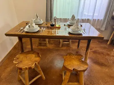 a wooden table with chairs and plates on it at Vacation House in Ontario - Two Bedroom Brand New and Hand Made Furniture in Ontario