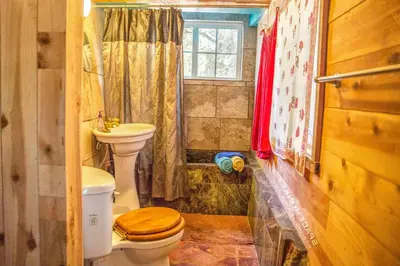 a bathroom with a toilet and a sink and a window at Topanga Wonderland Cottage in Topanga