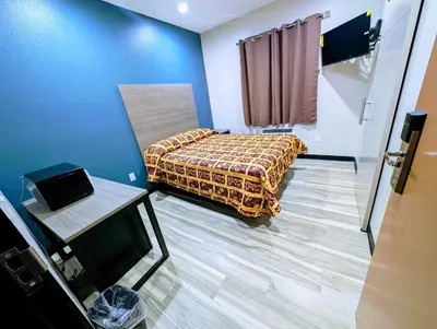a small room with a bed and a table at Star Inn Hotel in Maywood