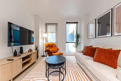 a living room with a couch and a tv at Stylish 2BDR & 2BTH - 15 mins walk to the beach! in Los Angeles