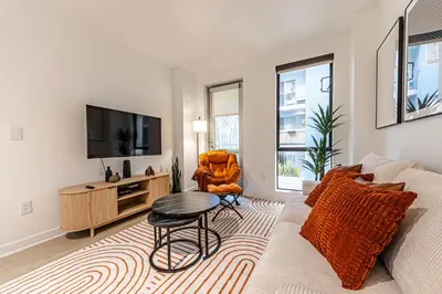 a living room with a couch and a tv at Stylish 2BDR & 2BTH - 15 mins walk to the beach! in Los Angeles